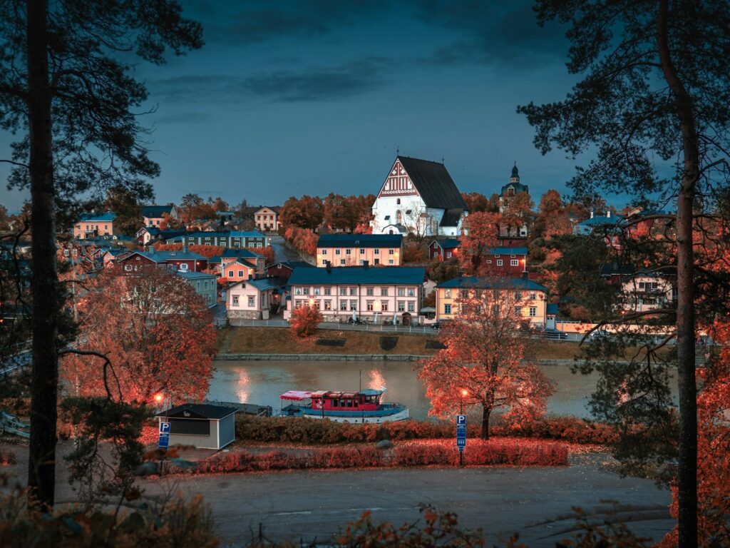 white concrete buildings beside body of water at night